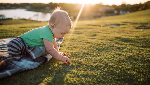 Humana Baby krabbelt im Gras