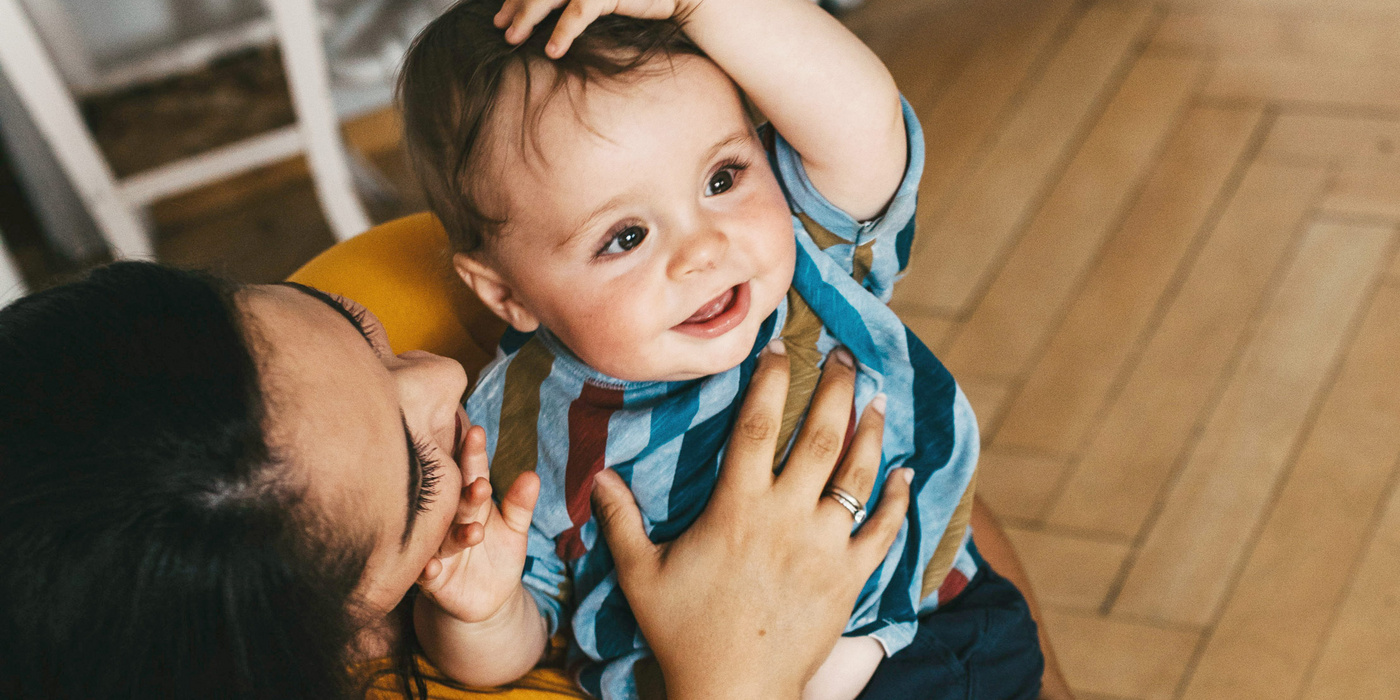 Humana Mama spielt mit ihrem Baby