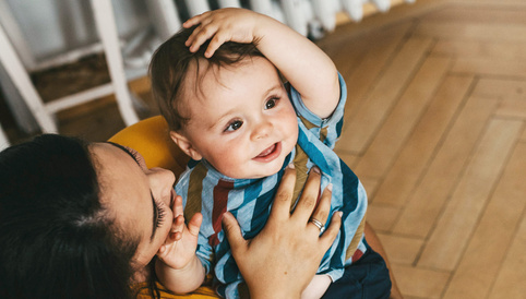 Humana Mama spielt mit ihrem Baby