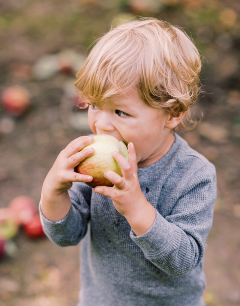 Humana Kind isst einen Apfel