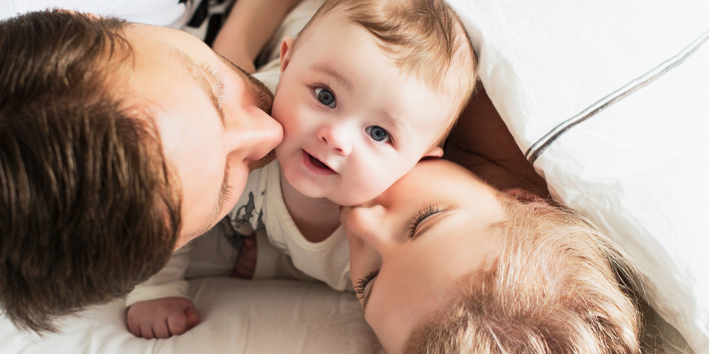 Humana Eltern küssen Baby
