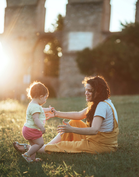 Humana Mama spielt mit Baby im Garten