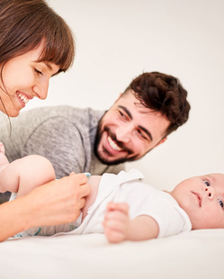Humana glückliche Eltern spielen mit Baby