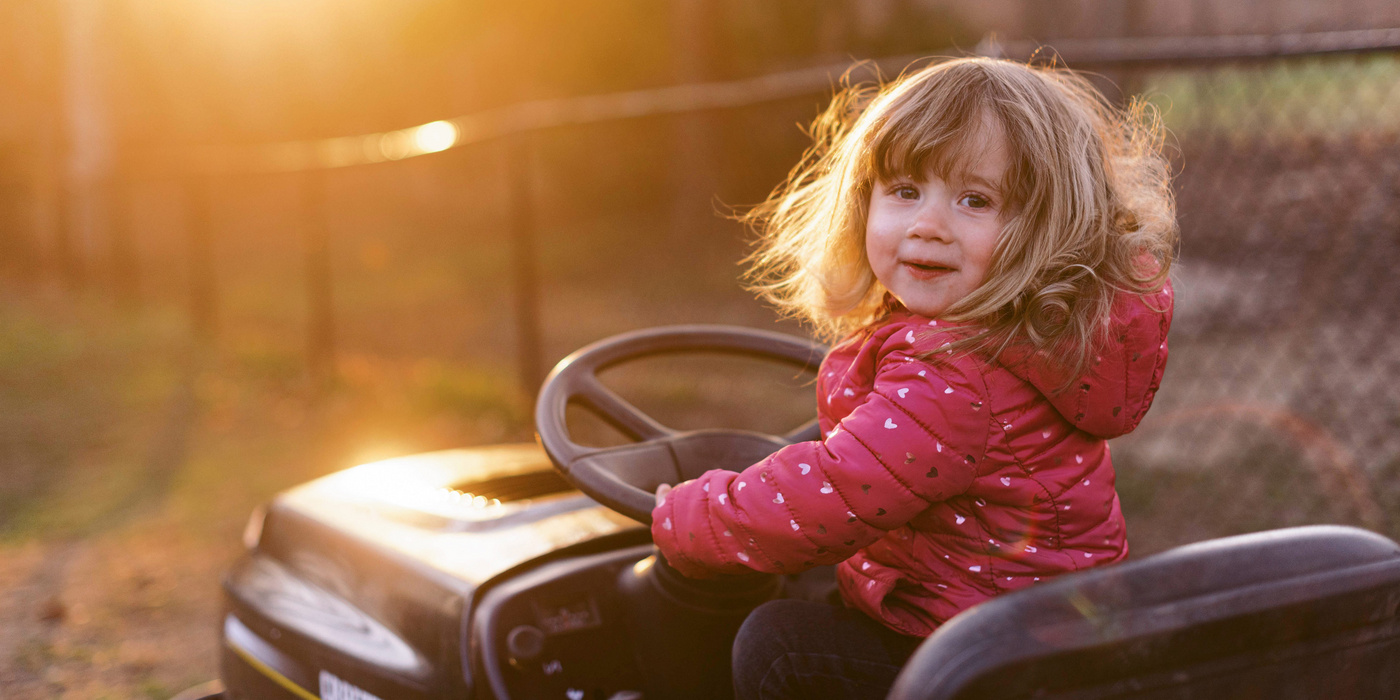 Humana kleines Mädchen fährt Miniauto