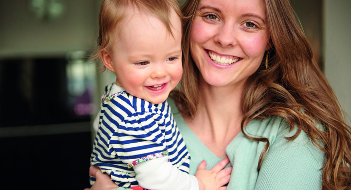 Happy mother carrying happy baby 