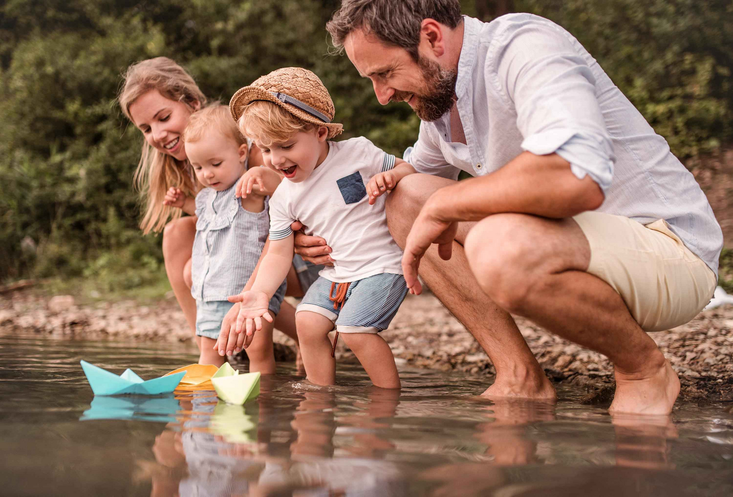 Humana Familie spielt am See