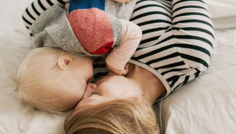 Humana Baby und Mama kuscheln im Bett