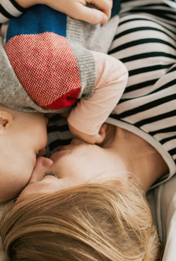 Humana Baby und Mama kuscheln im Bett